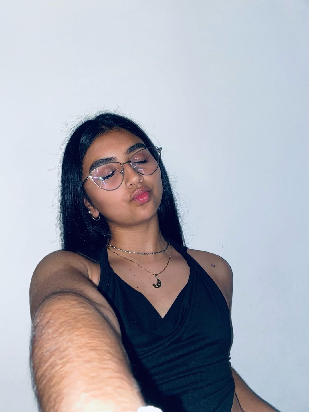 A woman from Puerto Rico in glasses, looking at her screen before typing to a stranger